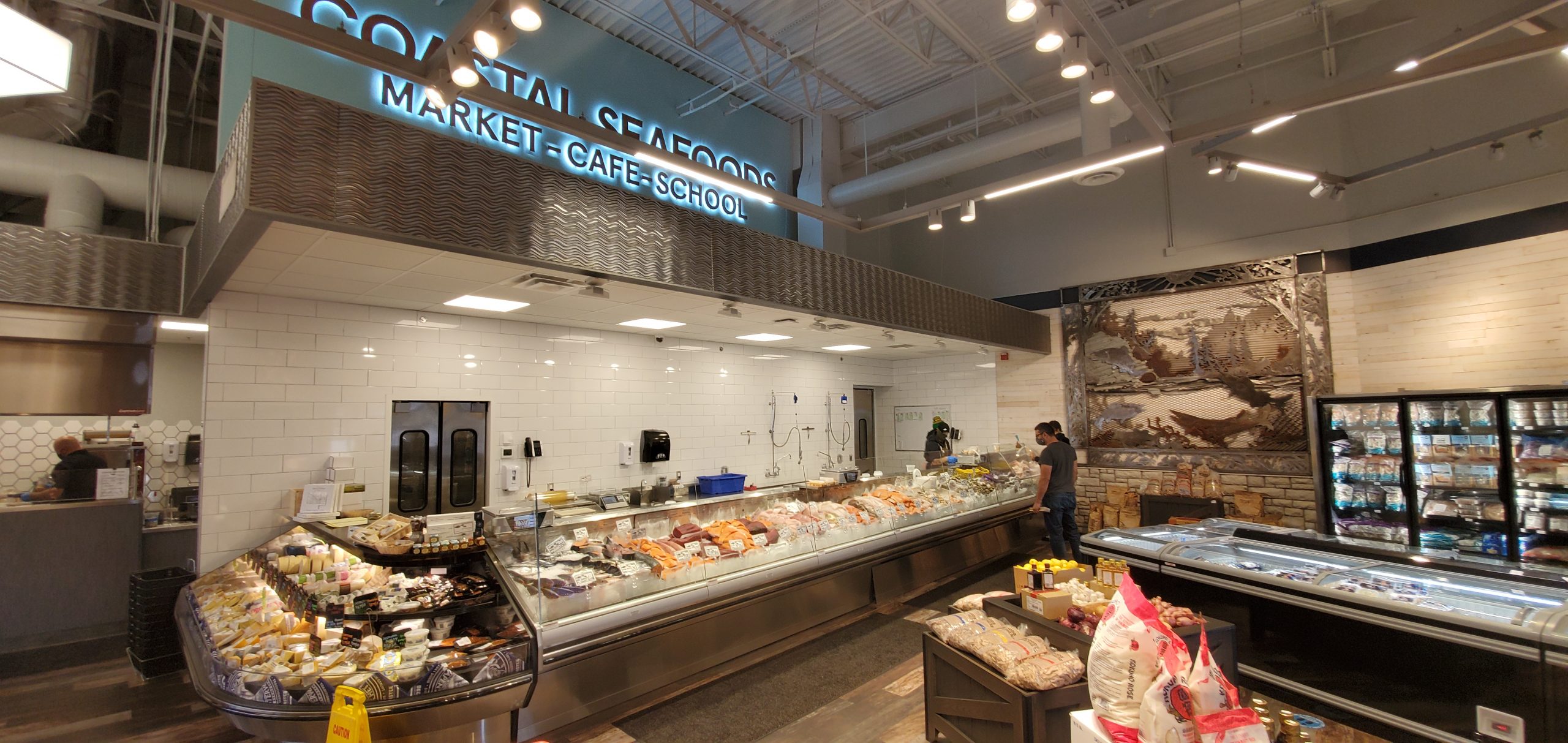 StoreMasters chose custom fixtures to offer full views and encourage customer interaction with the Coastal Seafood team